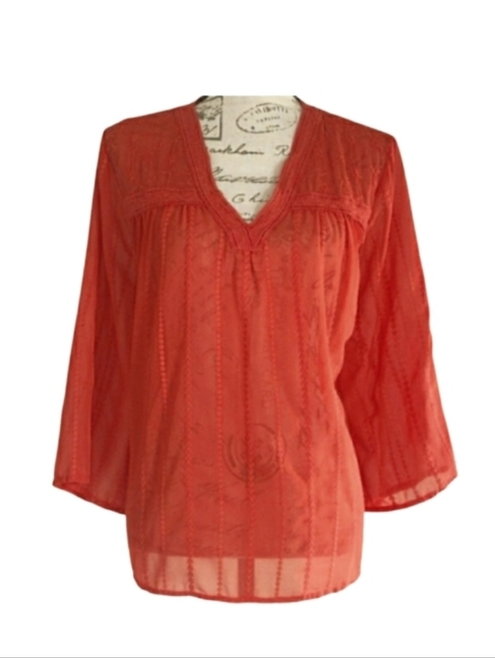 Sheer embroidered orange blouse.